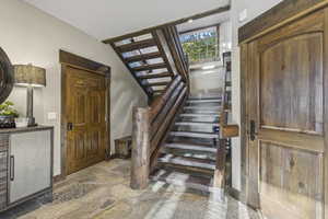 Staircase with stone finish floors and baseboards