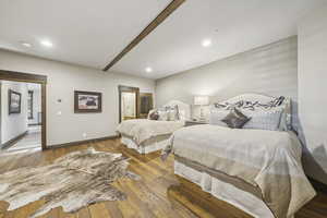 Bedroom with wood-type flooring, ensuite bath, and recessed lighting