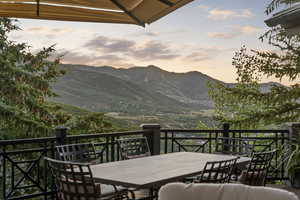 Balcony at dusk featuring outdoor dining area and a mountain view