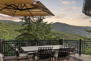 Wooden deck featuring outdoor dining area and a mountain view