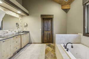 Bathroom with double vanity, backsplash, a tub with jets, and wood ceiling