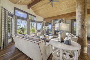 Living room with a wood ceiling with exposed beams, dark wood finished floors, high vaulted ceiling, a fireplace, and ceiling fan