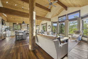 Living room with high vaulted ceiling, dark wood-style flooring, ceiling fan, a wood ceiling with exposed beams, and recessed lighting