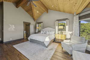 Bedroom with high vaulted ceiling, hardwood / wood-style floors, ceiling fan, and a wood ceiling with exposed beams