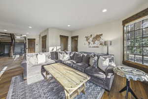 Living area with recessed lighting, stairs, and hardwood / wood-style floors