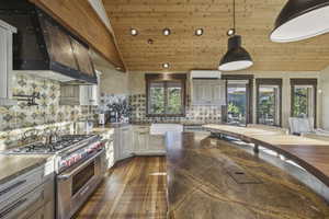 Kitchen with butcher block counters, wooden ceiling, premium stove, backsplash, and custom exhaust hood