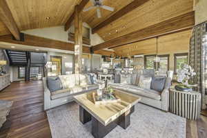 Living room featuring wood-type flooring, plenty of natural light, high vaulted ceiling, stairs, and recessed lighting