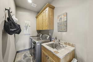 Laundry room featuring cabinet space, washer and clothes dryer, stone finish flooring, baseboard heating, and recessed lighting