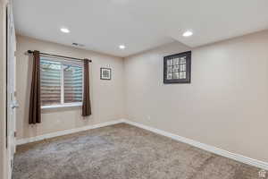Carpeted empty room featuring recessed lighting