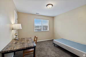 Office area featuring dark colored carpet and baseboards