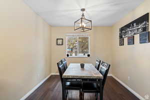 Dining space featuring dark wood-type flooring and a chandelier