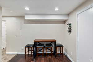 Dining area featuring a textured ceiling, recessed lighting, dark wood-style flooring, and electric panel