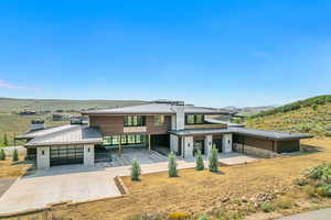 View of front of house with a metal roof, a mountain view, concrete driveway, and a standing seam roof