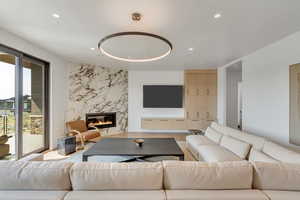 Living area featuring a premium fireplace, recessed lighting, and wood finished floors