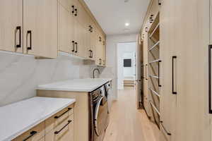 Kitchen featuring light brown cabinetry, light wood-style flooring, light stone countertops, modern cabinets, and recessed lighting