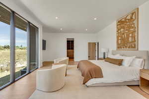 Bedroom with recessed lighting, wood finished floors, and a walk in closet