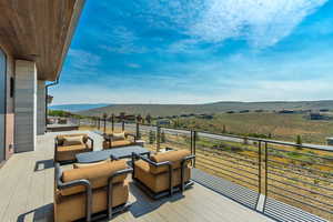 Wooden terrace with an outdoor hangout area, a mountain view, and a view of rural / pastoral area