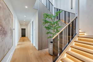 Stairs featuring wood finished floors and recessed lighting