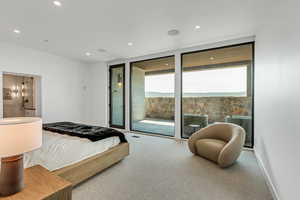 Bedroom with carpet flooring, access to exterior, expansive windows, recessed lighting, and connected bathroom
