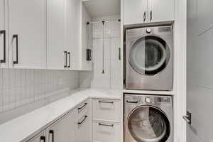Laundry room featuring cabinet space and stacked washer / dryer