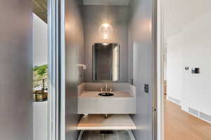 Bathroom featuring wood finished floors, vanity, and elevator