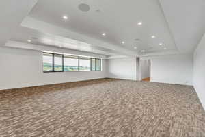 Unfurnished room with a tray ceiling, carpet flooring, and recessed lighting