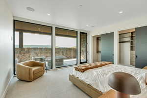 Carpeted bedroom featuring multiple closets, access to exterior, and recessed lighting