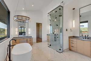 Bathroom with a marble finish shower, plenty of natural light, light marble finish floors, and recessed lighting