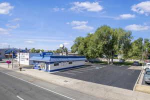 View of asphalt street featuring curbs and street lighting