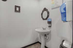 Bathroom with baseboards and speckle patterned floor