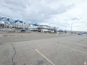 View of asphalt street with a mountain view, curbs, and sidewalks