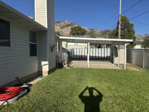 View of yard featuring a mountain view, a patio, and a storage unit