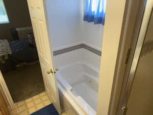 Full bathroom featuring a tub with jets and tile patterned floors