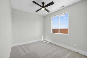 Spare room with light colored carpet and a ceiling fan