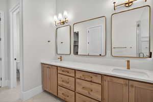 Full bath with double vanity, a stall shower, and light tile patterned flooring