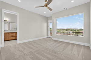 Unfurnished bedroom with light carpet, access to outside, a ceiling fan, recessed lighting, and ensuite bath