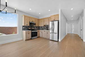 Kitchen with light brown cabinets, appliances with stainless steel finishes, light countertops, and recessed lighting