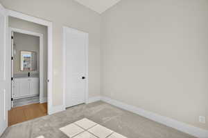 Unfurnished bedroom featuring light colored carpet and baseboards