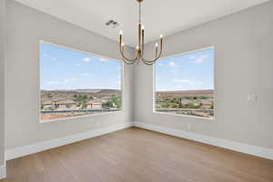Unfurnished dining area with a chandelier and light wood-style flooring