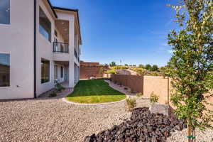 Fenced backyard featuring a balcony and a patio