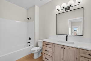 Full bathroom with shower / bathtub combination, light wood-style floors, and vanity
