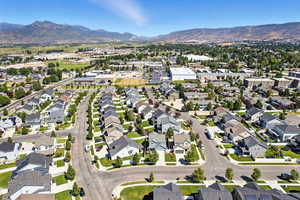 Aerial view of property and surrounding area with nearby suburban area and mountains
