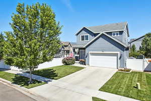 Traditional home with a garage, driveway, stucco siding, and a residential view