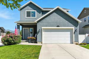 Traditional-style house featuring a porch, stucco siding, driveway, and an attached garage