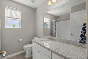 Bathroom featuring vanity, light tile patterned floors, a shower with shower curtain, and a textured ceiling