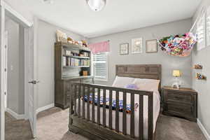 Bedroom with light colored carpet and a textured ceiling