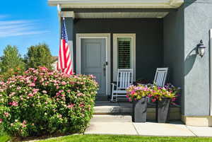 Entrance to property with covered porch and stucco siding