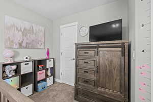 Bedroom with light colored carpet and a textured ceiling