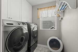 Laundry room with cabinet space and washing machine and clothes dryer
