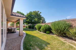 Fenced backyard with a patio area and ceiling fan